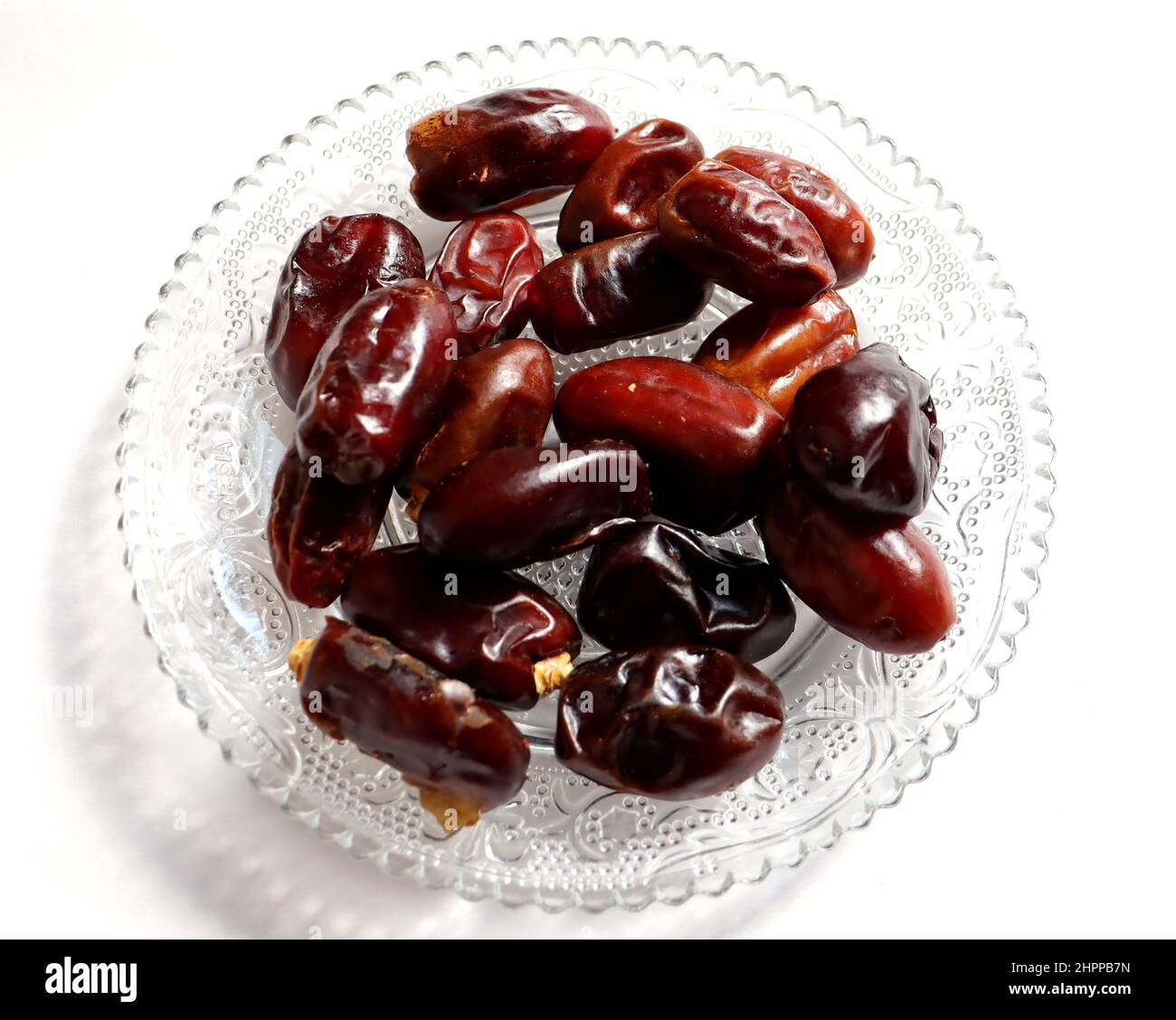 Dates on a glass plate with white background,high antioxidants and high fiber,eat as a snack Stock Photo