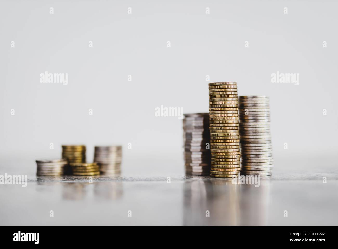 stacks of different coins divided between a small and a big group on ...
