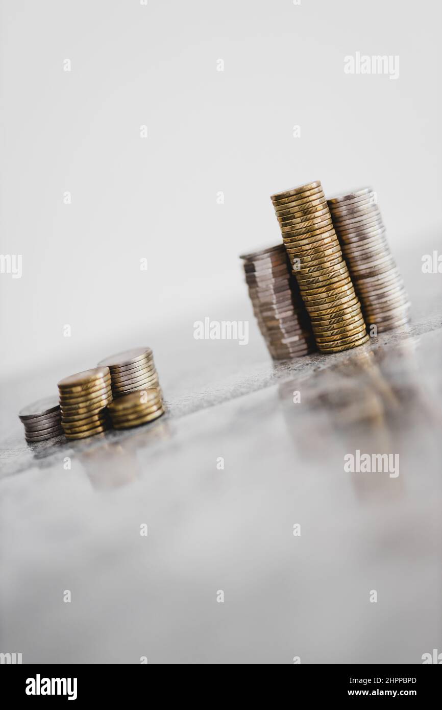 stacks of different coins divided between a small and a big group on ...