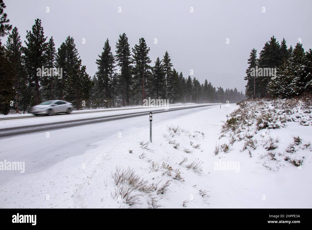 Reno, United States. 22nd Feb, 2022. A car drives on a snow covered road. Winter road conditions