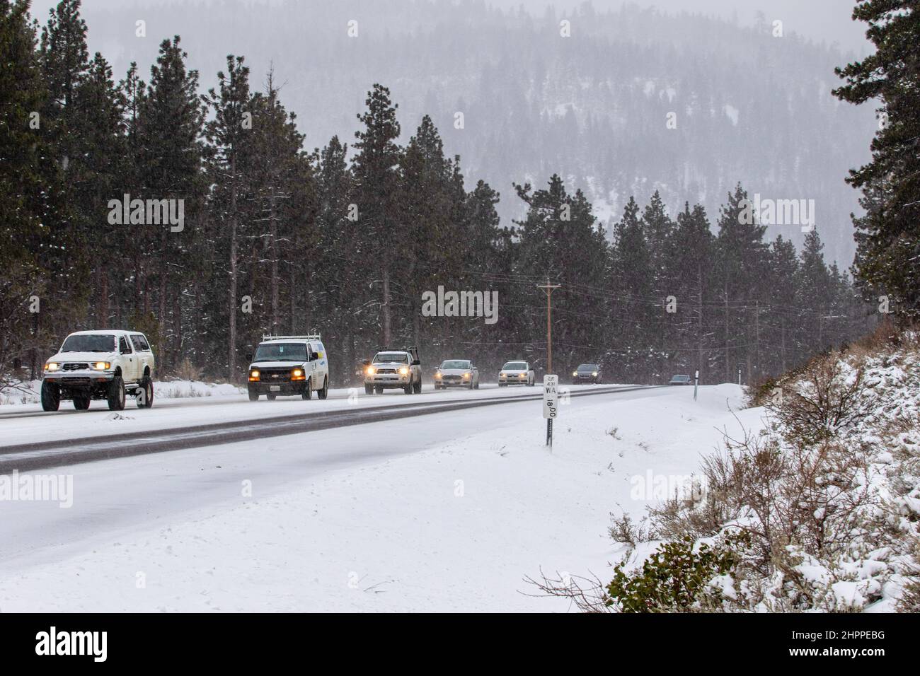 Reno, United States. 22nd Feb, 2022. A line of cars descend a mountain road  in winter weather. Winter road conditions worsen as snow falls in the  mountains. Chains where required on all