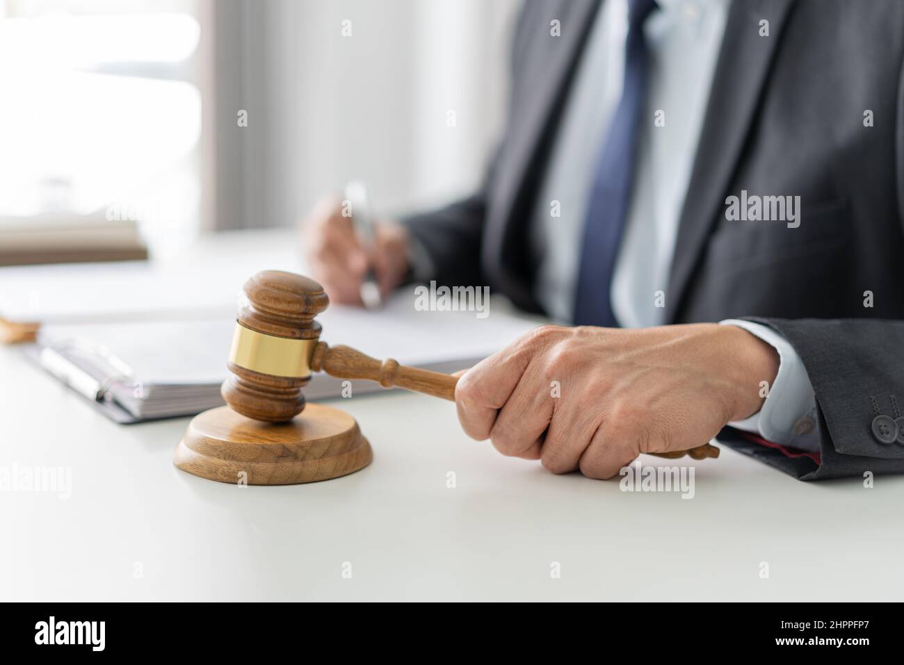 law concept the lawyer in dark bule suit signing his signature on the official document and