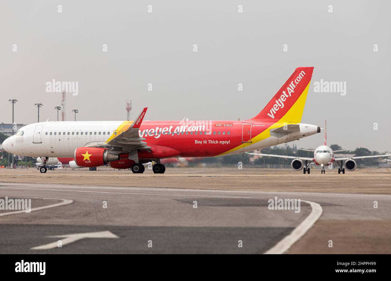 Chiang Mai, Thailand. 22nd Feb, 2022. Thai VietjetAir airplane (L) and Thai AirAsia airplane (R) seen on the apron at Chiang Mai International Airport (CNX).Thailand has raised the COVID-19 alert to level 4 following a sharp increase in omicron variant infections nationwide. Credit: SOPA Images Limited/Alamy Live News Stock Photo