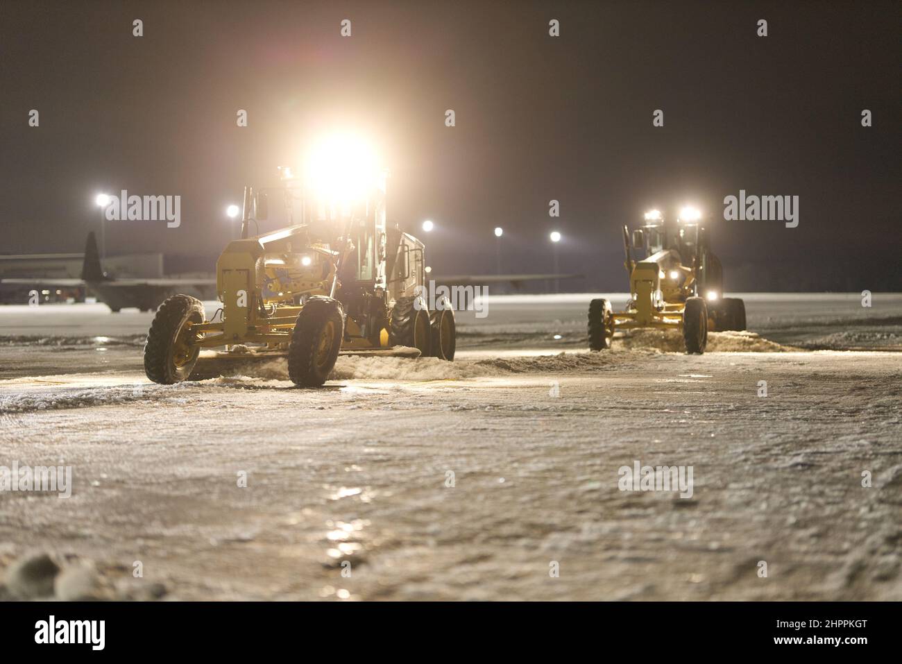 Senior Airman Austin Schafer, 19th Civil Engineer Squadron, left, and Senior Airman Jason Bridgman, 19th CES, right, clear the flightline of snow and ice following a winter storm at Little Rock Air Force Base, Arkansas, Feb. 4, 2022. Civil engineers from the 19th CES worked day and night to keep LRAFB operational during Winter Storm Landon. (U.S. Air Force photo by 1st Lt. Daniel Hendrix) Stock Photo