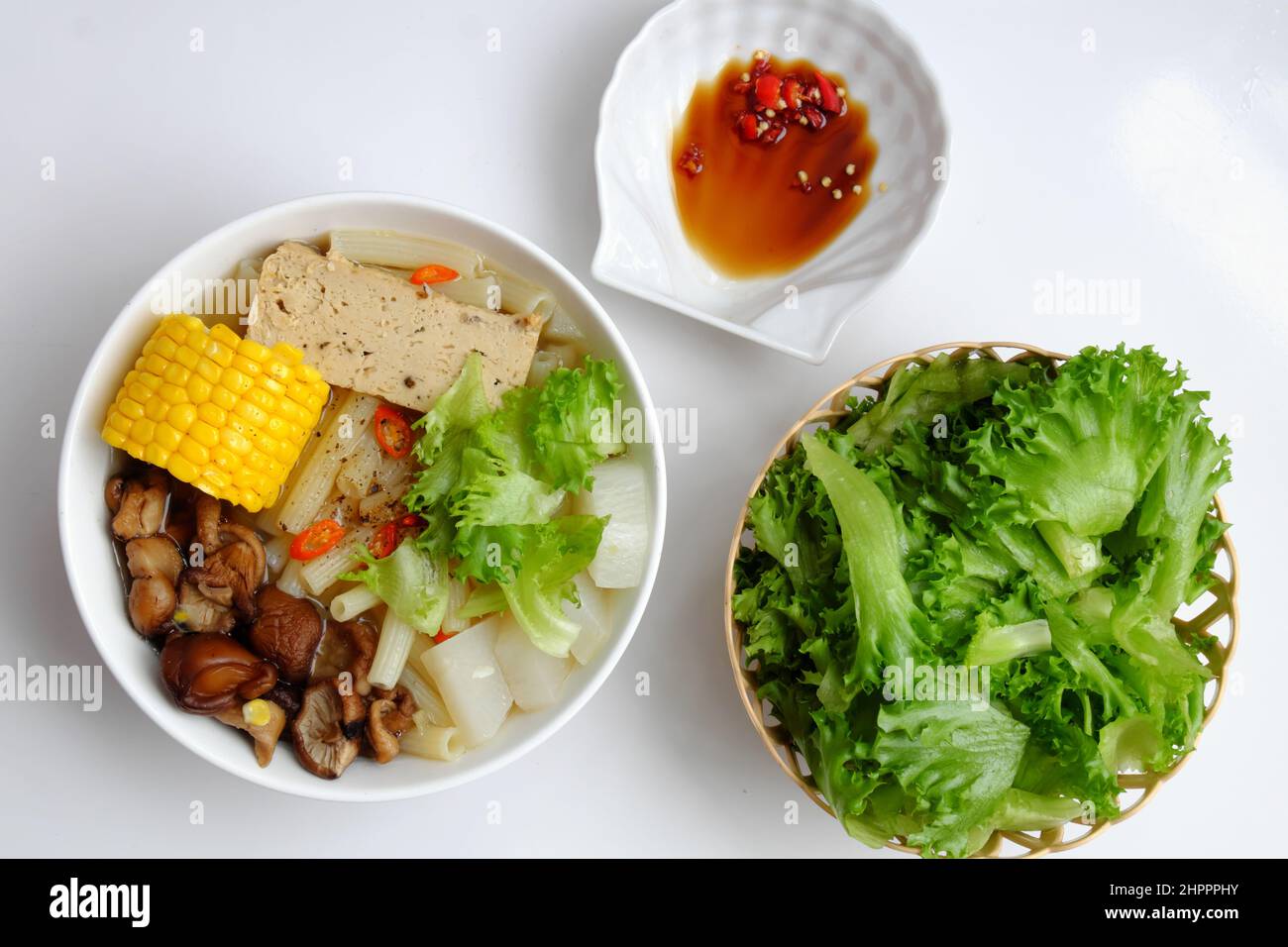 Top view Vietnamese vegan food for diet meal, vegetarian macaroni soup bowl with raw material as radish, mushroom, corn, salad, non meat eating good f Stock Photo