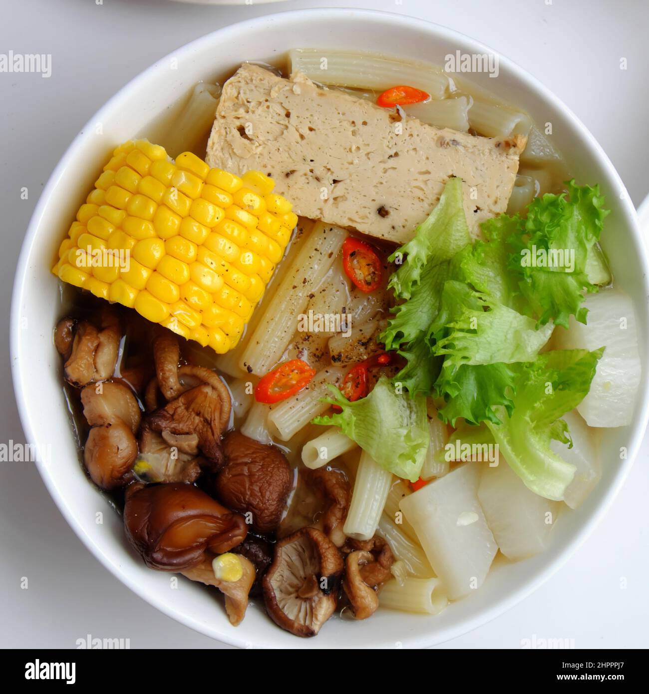 Top view Vietnamese vegan food for diet meal, vegetarian macaroni soup bowl with raw material as radish, mushroom, corn, salad, non meat eating good f Stock Photo