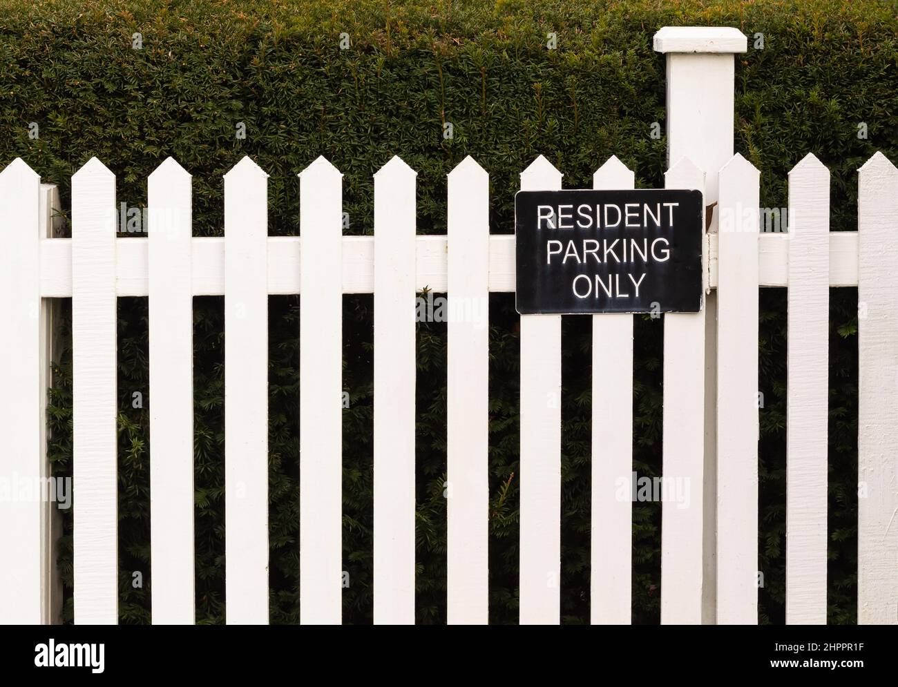 Parking for residents only sign on a white wooden fence Stock Photo