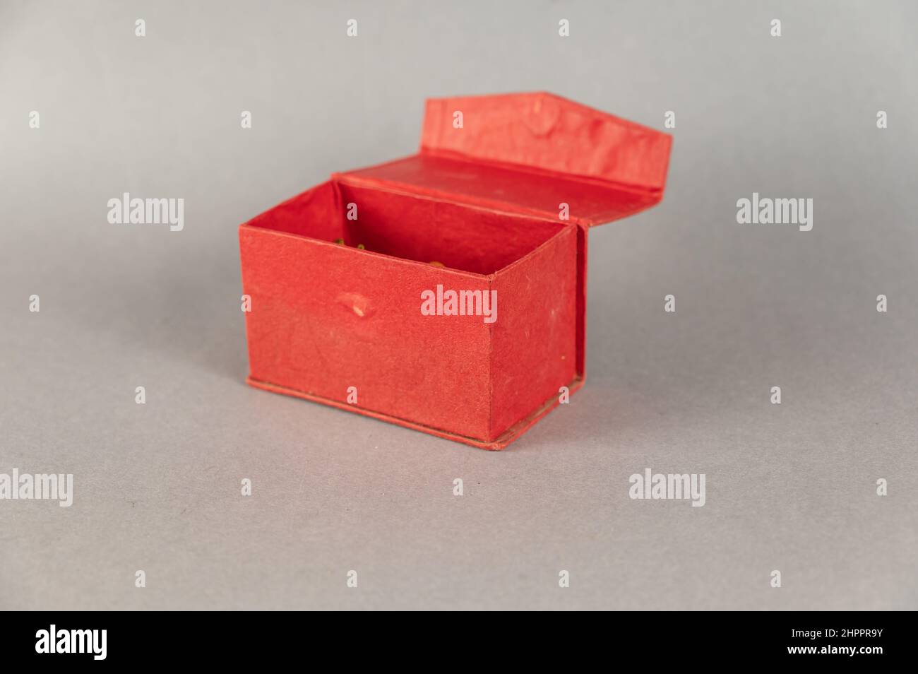 Empty Open red rectangular box on gray background. Close-up. Selective focus. Stock Photo