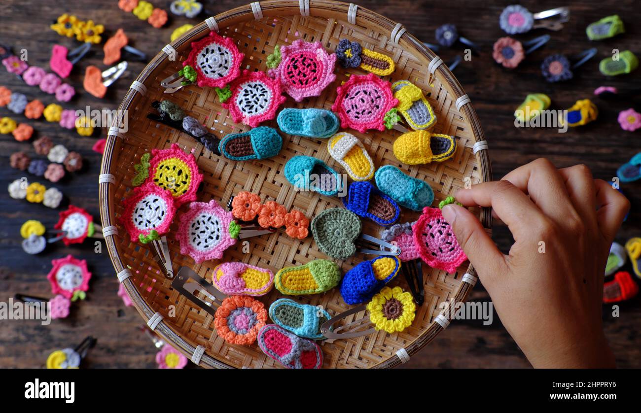 Top view Vietnamese woman hand hold handmade product, crochet hair pin in many shape and colorful, pretty handcraft gift accessories for beauty on bla Stock Photo