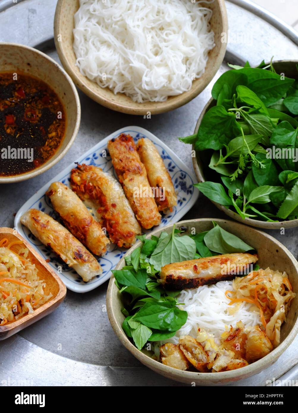 Top view tray of Vietnamese food for daily family meal weekend, fried spring roll rice noodles with lettuce and basil leaf and soy sauce, vegan dish g Stock Photo