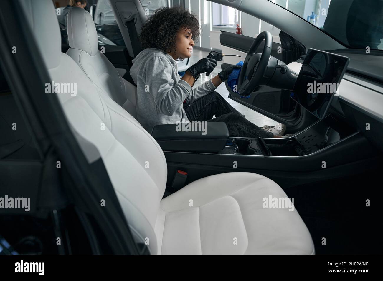 Focused female worker drying car interior surfaces Stock Photo Alamy