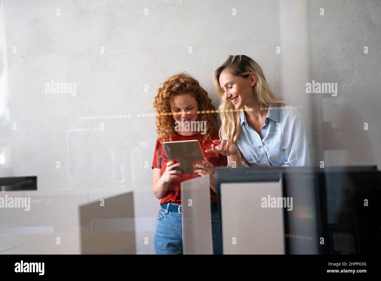 Happy smiling business women working together online on a tablet in office Stock Photo