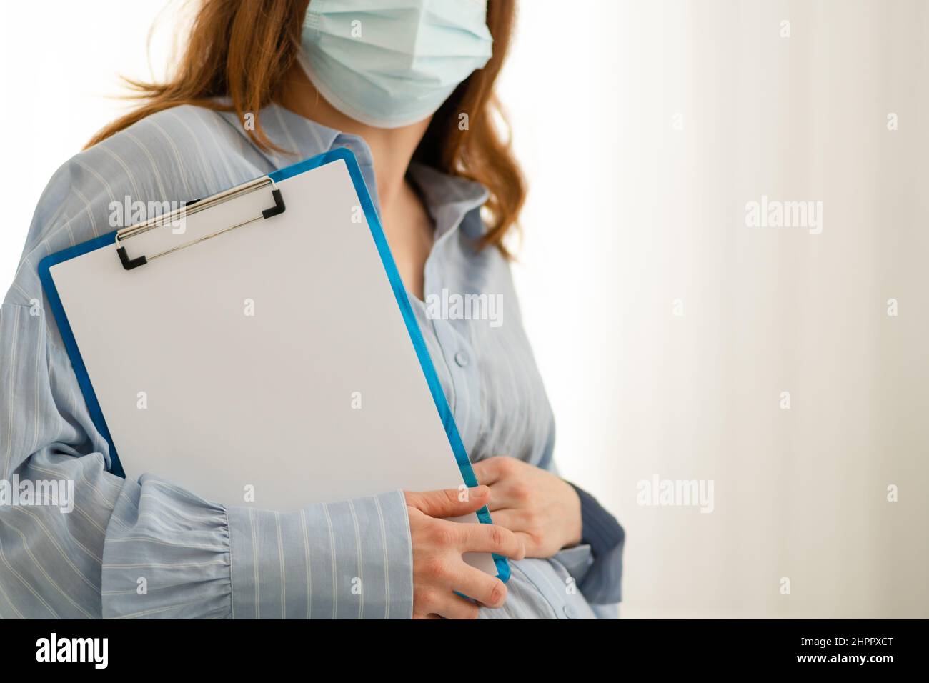 Pregnant woman hold blank white paper. Healthcare checkup during