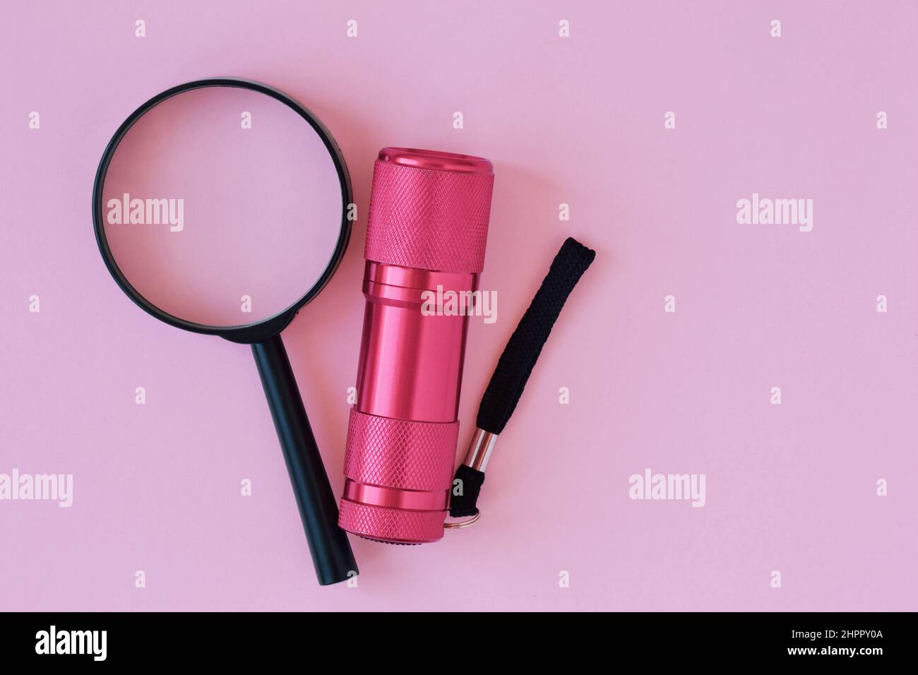 Magnifying glass with pink flashlight on pink background - Concept of research Stock Photo