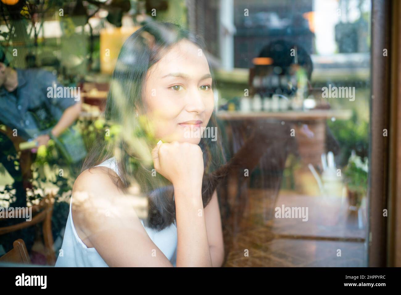 Beautiful asian women sitting in urban coffee shop looking out of window, Business women Stock Photo