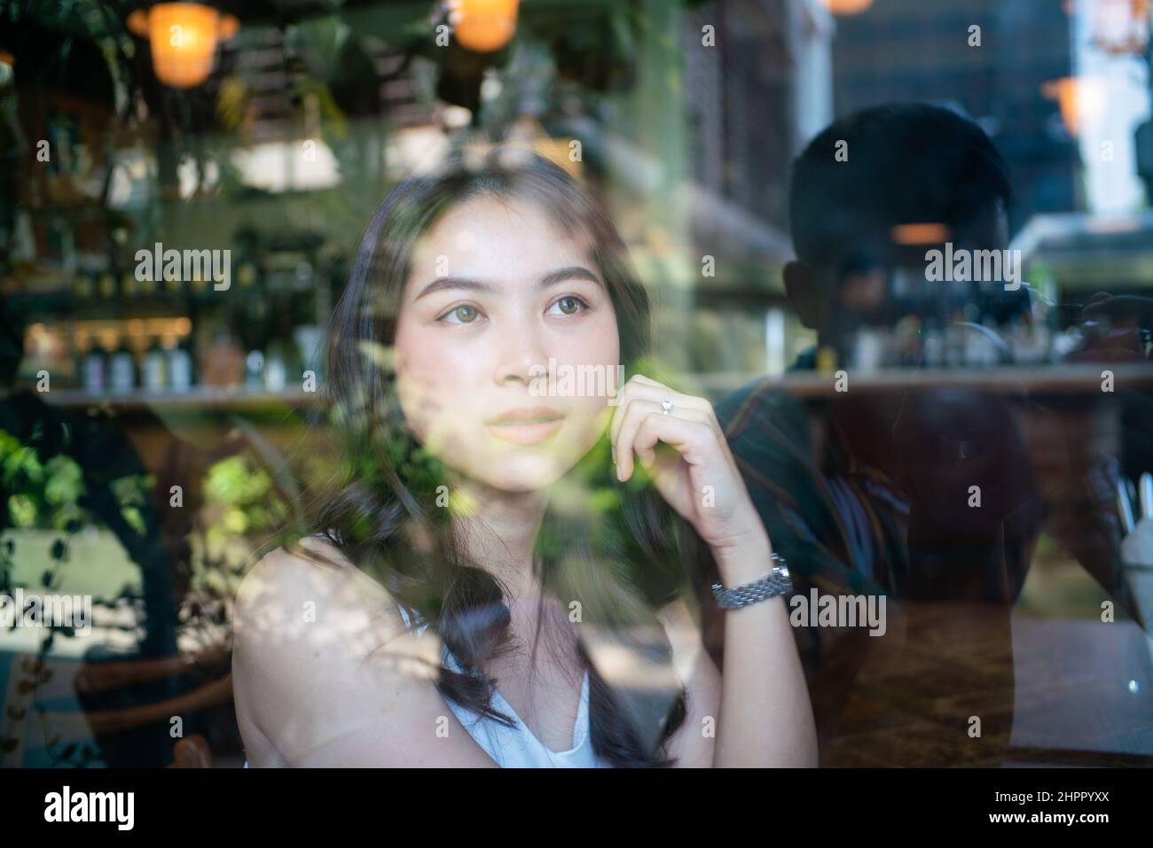 Beautiful asian women sitting in urban coffee shop looking out of window, Business women Stock Photo