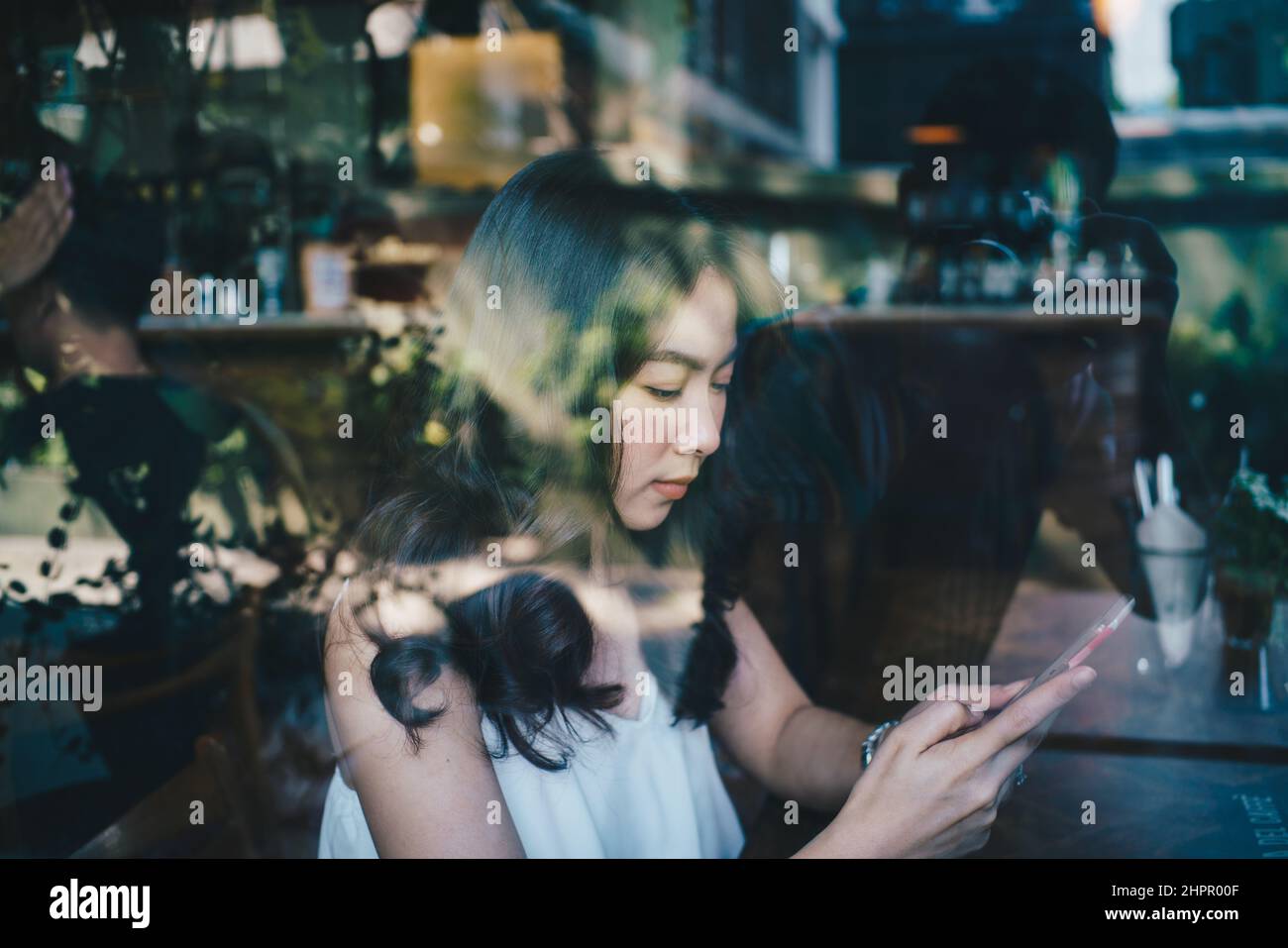 Business asian women use smartphone sitting in coffee shop day light ...