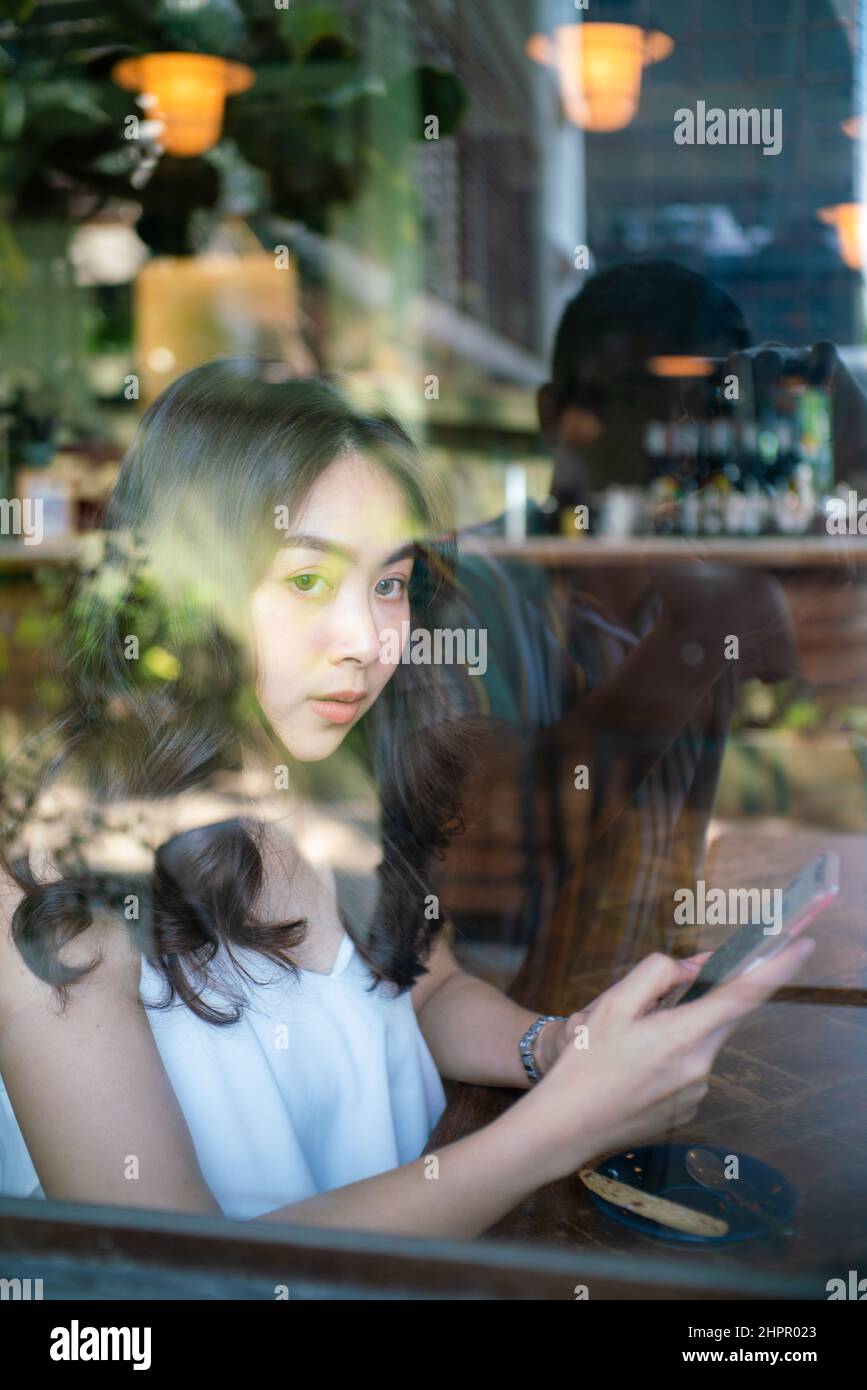 Business asian women use smartphone sitting in coffee shop day light ...
