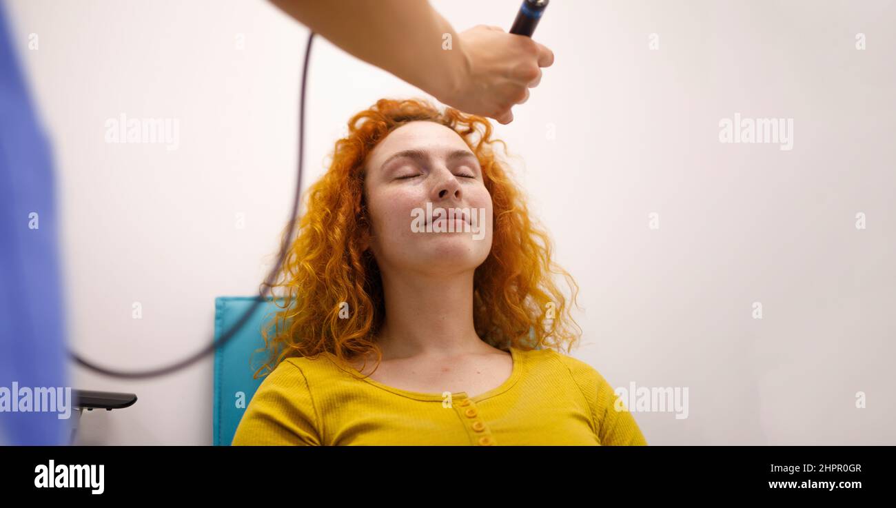An ophthalmologist checking the eye pressure of her long term patient Stock Photo