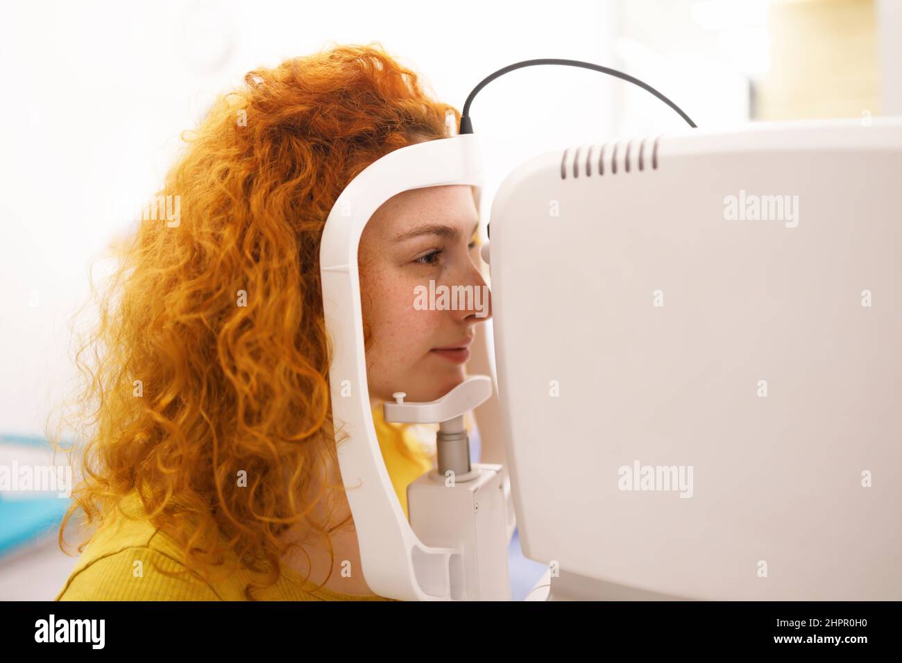 A woman during am eye pressure measurement at her eye clinic Stock Photo