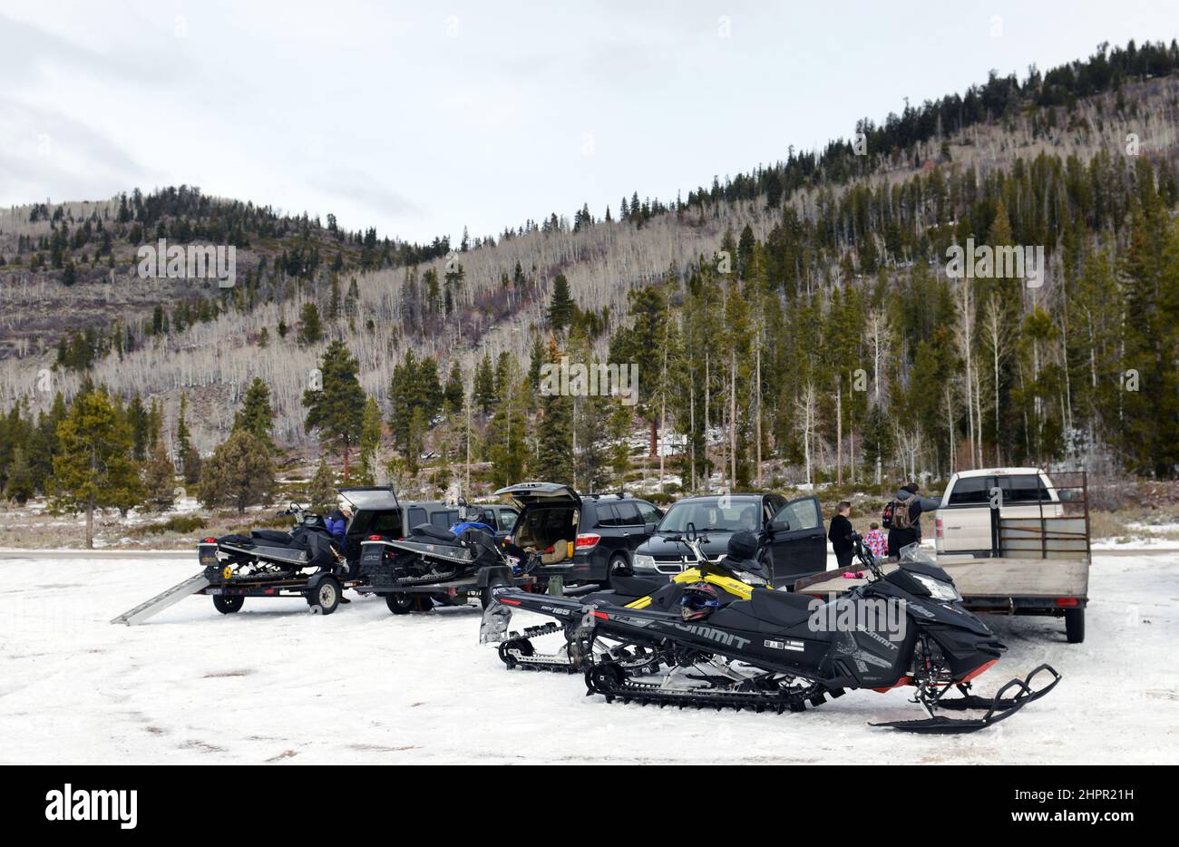 Snowmobiles and cars at the parking lot by the Provo river in the