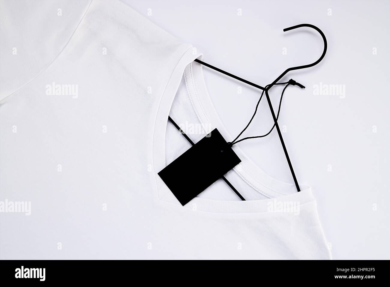 White cotton t-shirt mockup, on a black hanger. Close-up of a collar for a tag Stock Photo
