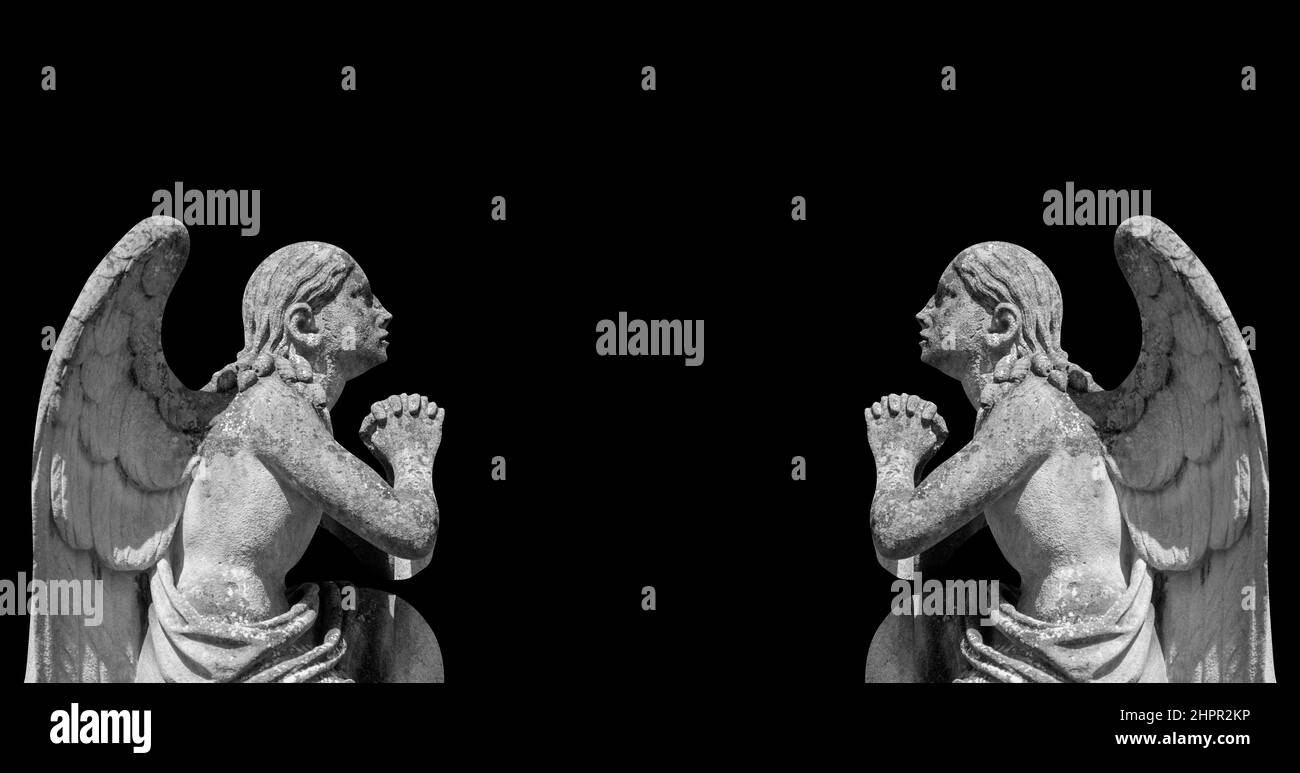 Ancient stone statues of angelsagainst black background. Copy space for