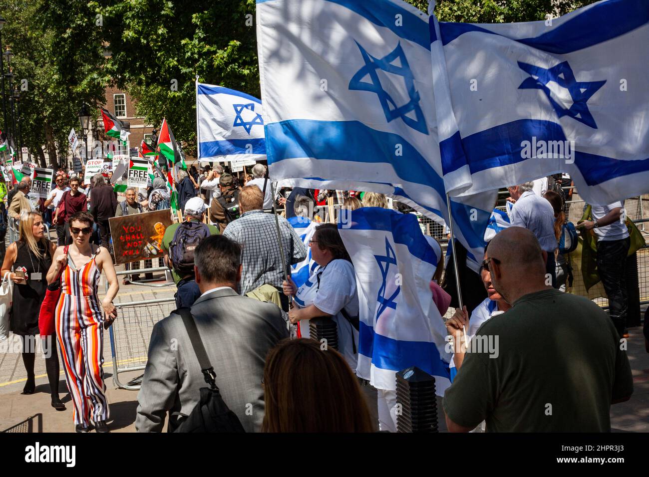 Rival demonstrations on Whitehall in London, opposite Downing St; Palestinian and Israeli groups with flags and banners kept apart by police Stock Photo