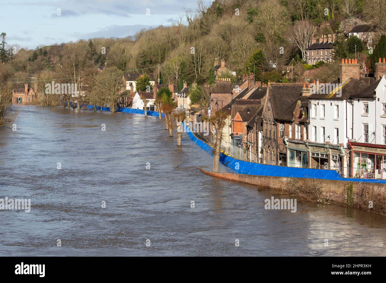 Shropshire, England. 23/02/2022, Flood barriers in the town of Ironbridge in Shropshire, continue to hold back the rising levels of the River Severn, which has been on the rise following a week of storms. All the residents from The Wharfage, the area behind the barriers, have been evacuated, as the risk of the river breaching the barriers remains. Stock Photo