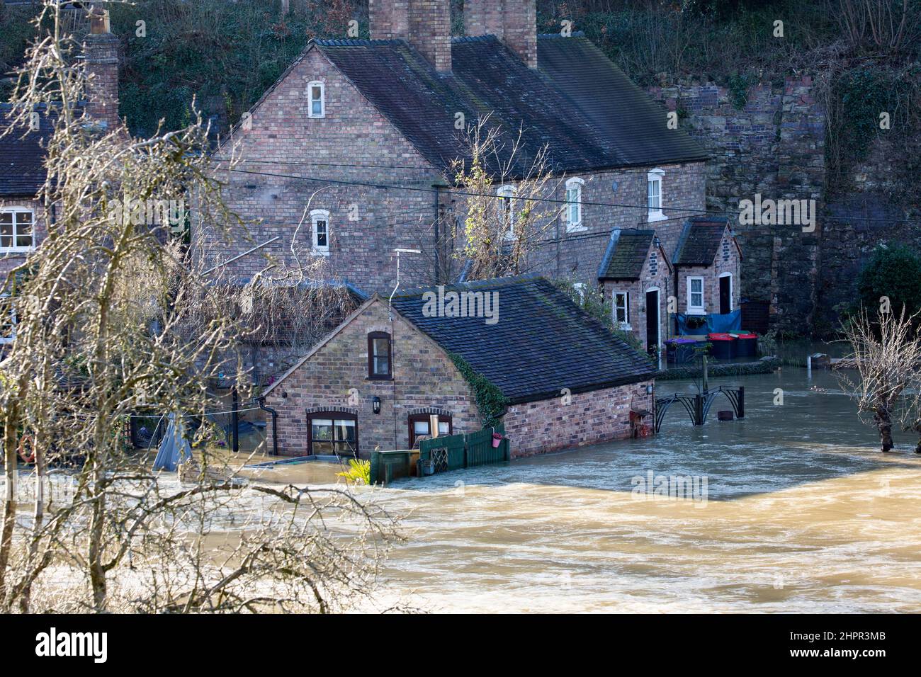 Shropshire, England. 23/02/2022,  Properties along the banks of the River Severn in The Ironbridge Gorge World Heritage Site in Shropshire, England, remain flooded as River Levels continue to remain high following a week of floods. Stock Photo
