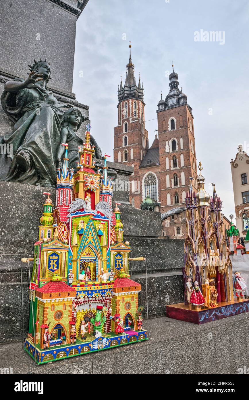 Kraków Szopka nativity scenes displayed during annual contest in December, Muse of Poetry with child figures at Adam Mickiewicz monument, Saint Mary's Church, Main Market Square, Kraków, Poland Stock Photo