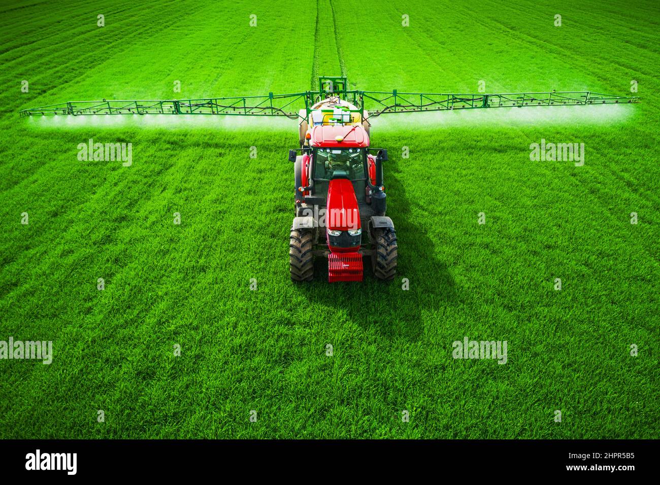 Aerial view of farming tractor plowing and spraying on field Stock ...