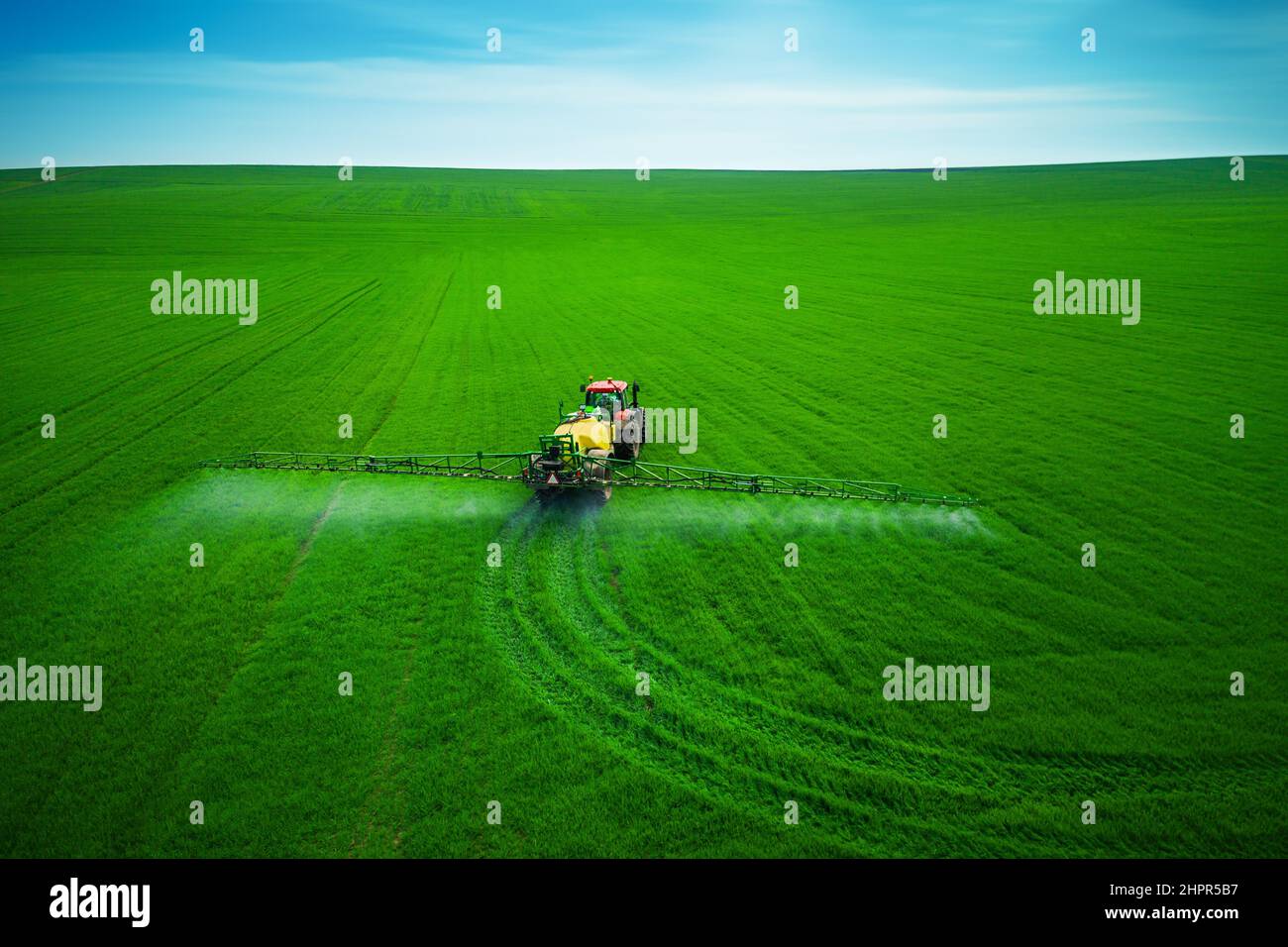 Aerial view of farming tractor plowing and spraying on field Stock ...