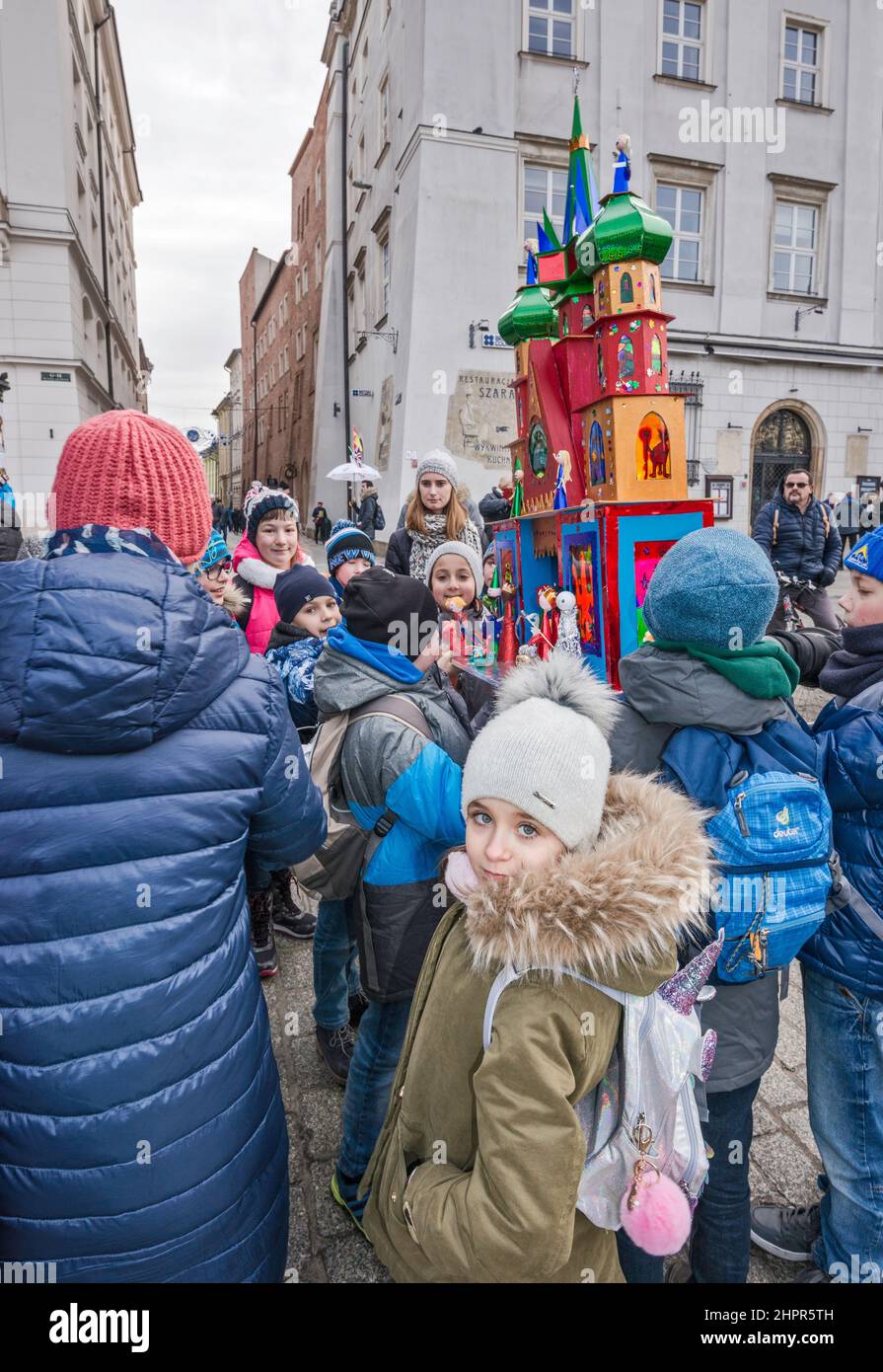 Schoolchildren  carrying Kraków Szopka nativity scene, made by them at school, for display during annual contest in December, event included in UNESCO Cultural Heritage list, at Main Market Square, Kraków, Poland Stock Photo