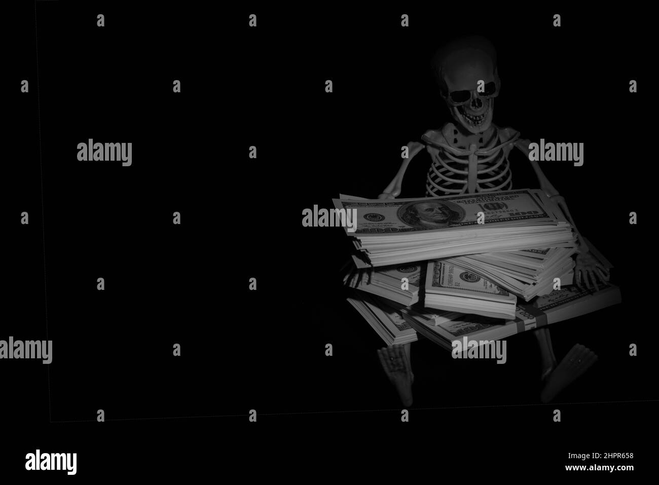 Skeleton skull with US Dollar money as symbol of wealth and greed. Copy space. Stock Photo