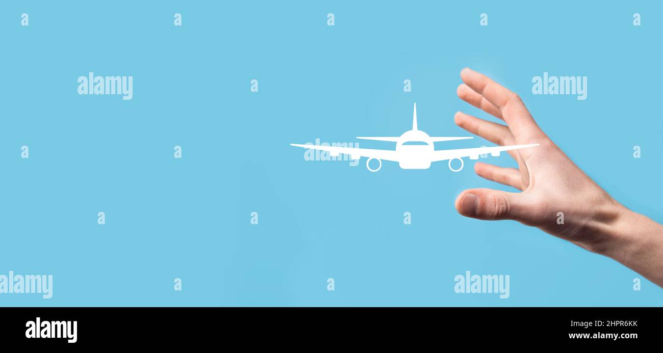 Male hand holding plane airplane icon on blue background. Banner.nline ticket purchase.Travel icons about travel planning, transportation, hotel, flig Stock Photo