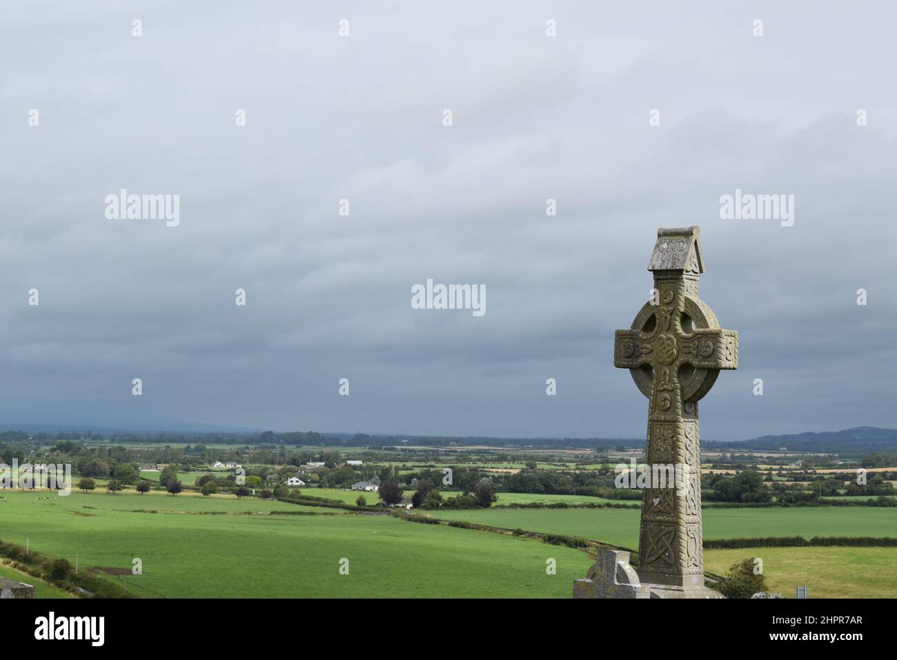 Ireland cross close up on a valley landscape. Cemetery on Rock of Cashel village. Green meadows on the background. Ireland. Stock Photo