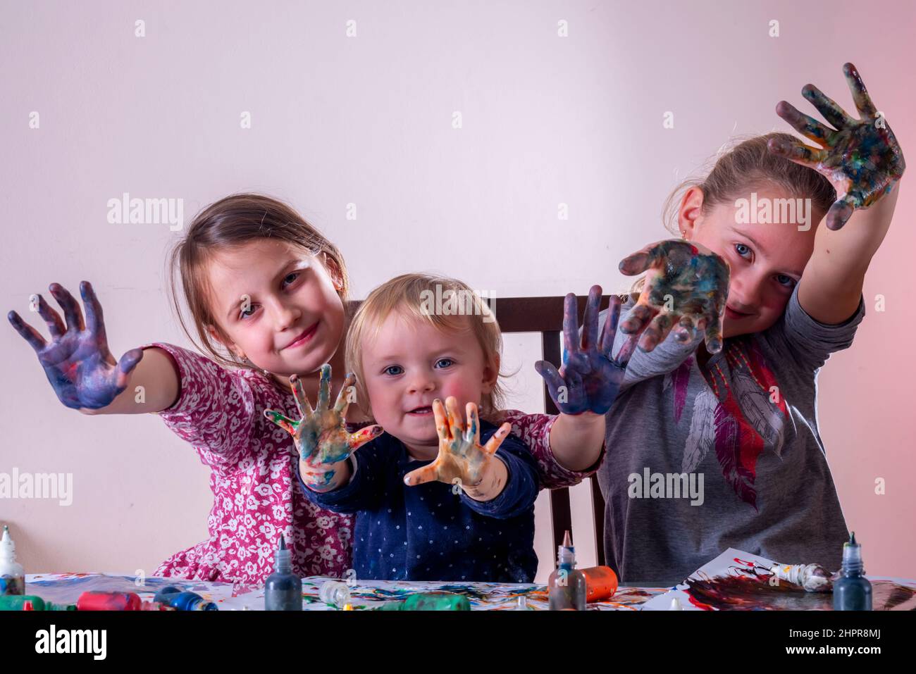 Portrait of happy little children with painted hands drawing and having ...