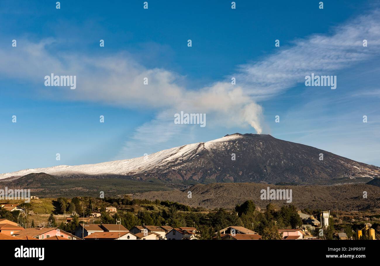 Smoke pours from the summit of Mount Etna, the most active volcano in Europe, seen from the small town of Bronte on its western flank (Sicily, Italy) Stock Photo
