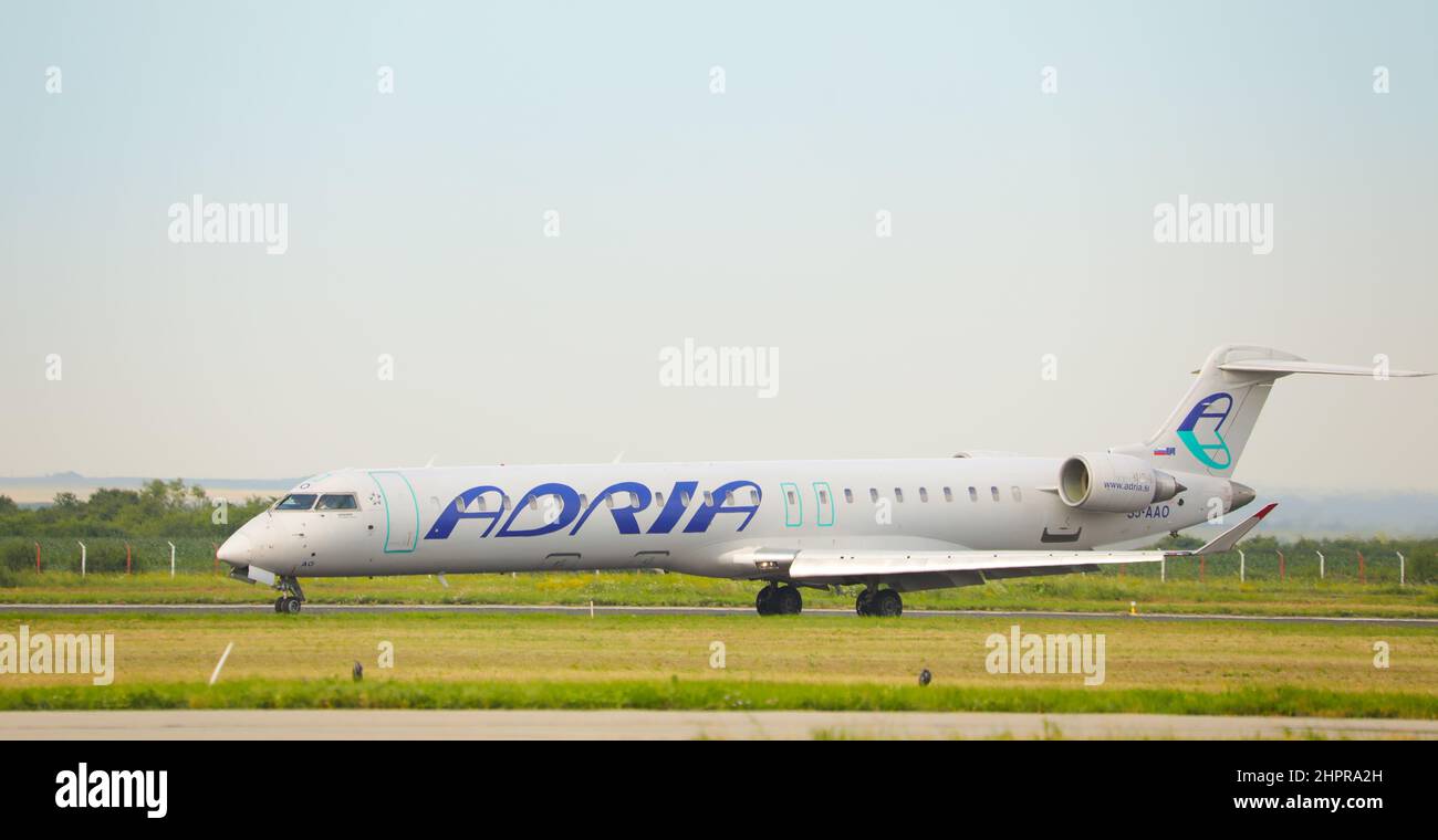 Commercial passenger jet airliner Bombardier CRJ900 of the Adria Airways Airline. Airplane is taxiing towards the runway ready for take off Stock Photo