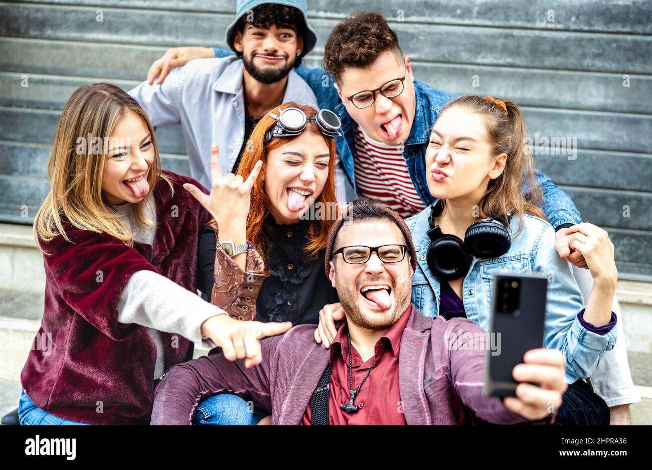 Multicultural best friends taking selfie out side at urban location - Happy millenial life style concept with young people students having fun togethe Stock Photo