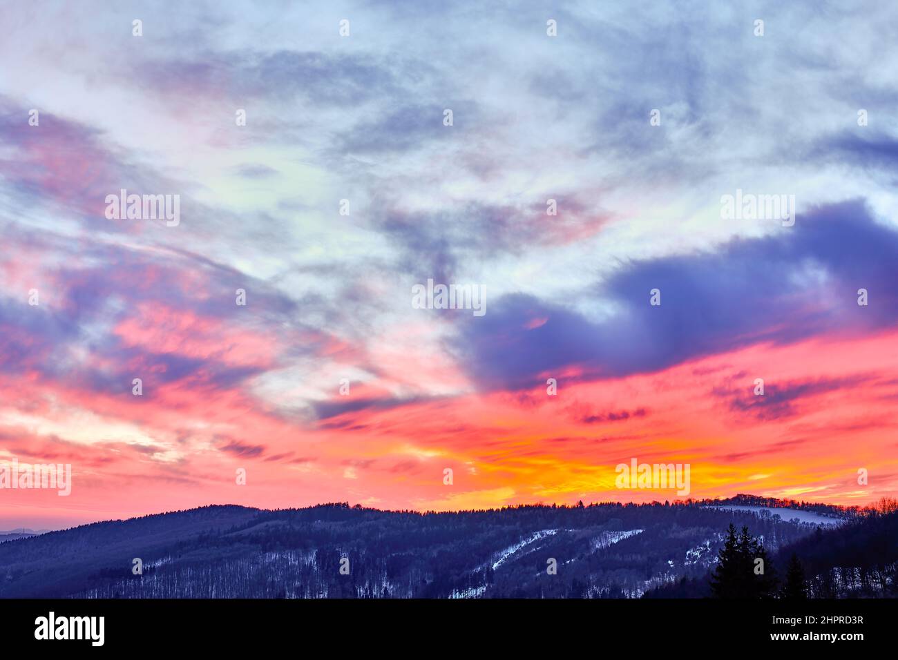 Beautiful sunset in a mountain landscape, dramatic glowing sky. Rolling ...