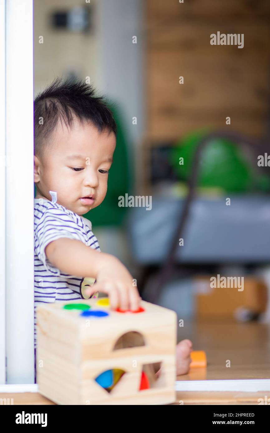 Baby infant boy playing wooden toy box in home 1 year boy Stock Photo Alamy