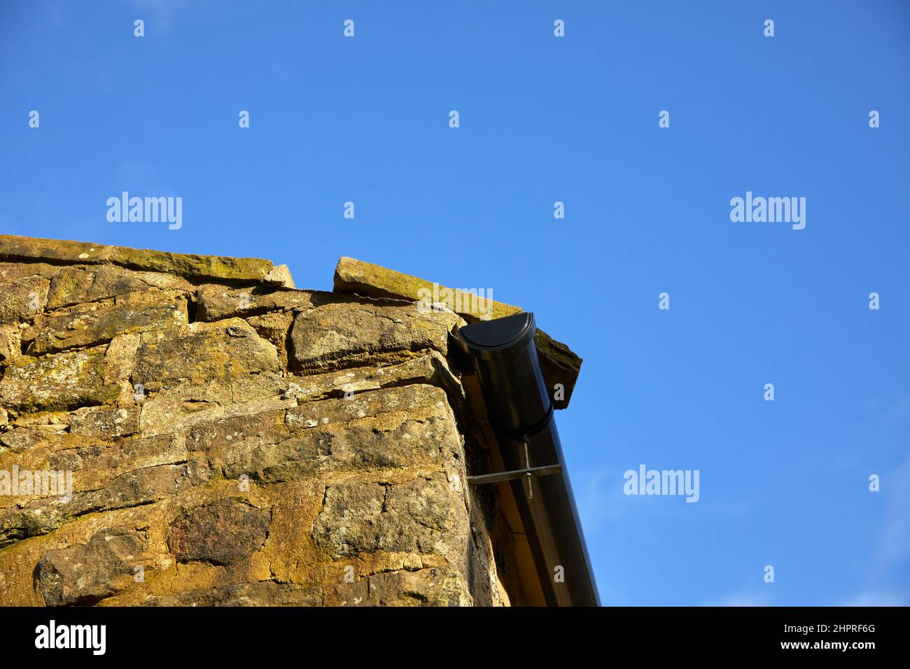 Storm damage to the gable end coping stone on a moorland farm barn at 900ft Stock Photo