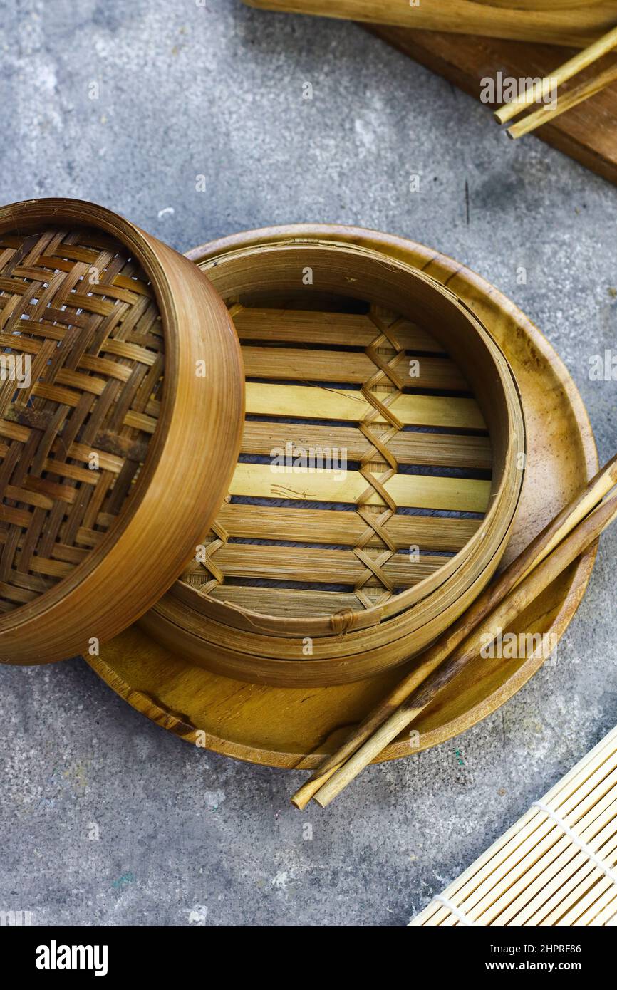 Bamboo steamer for dim sum or chinese food with wooden chopstick. Grey grainy background