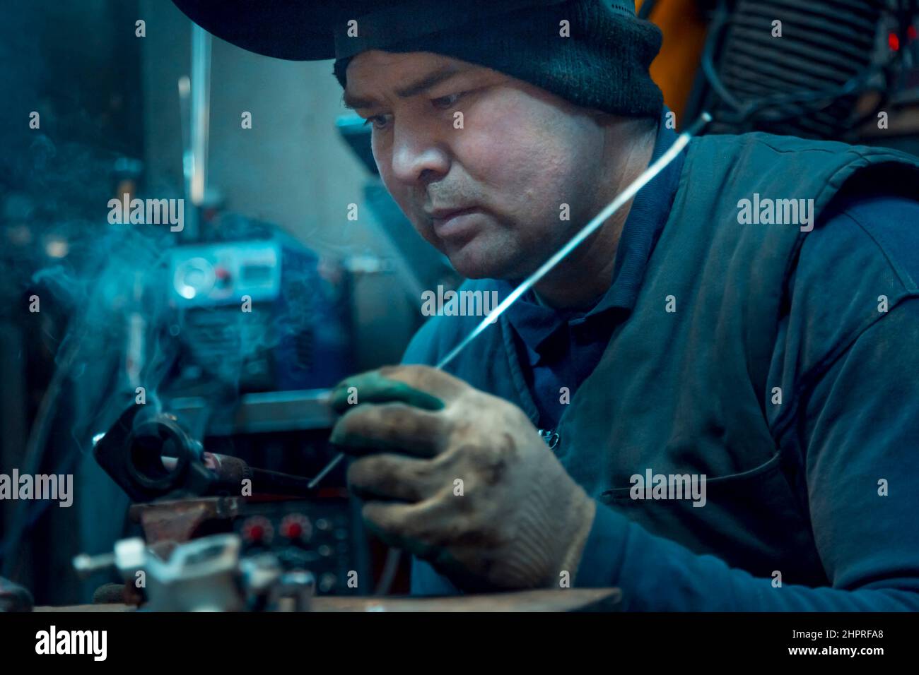 Portrait of an argon arc welder with a helmet on his head at the