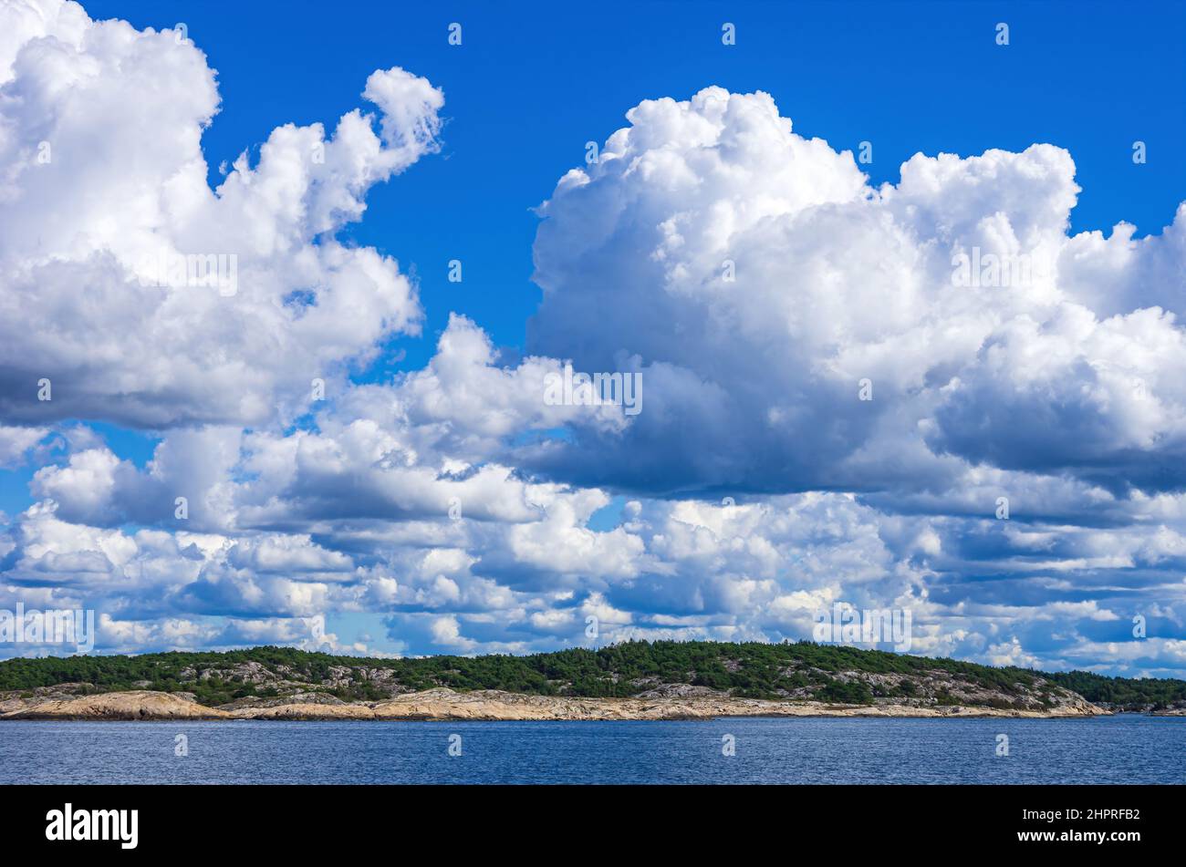 Skerries and coastline under a bright cloudy blue sky in the Koster fjord between the Koster islands and Strömstad, Bohuslän, Sweden. Stock Photo