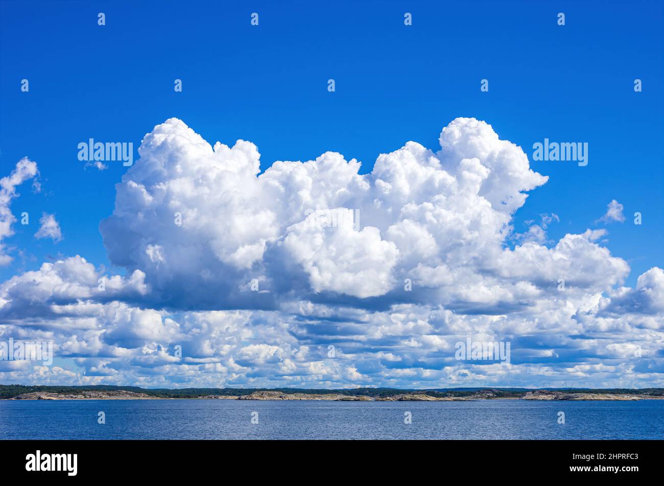 Skerries and coastline under a bright cloudy blue sky in the Koster fjord between the Koster islands and Strömstad, Bohuslän, Sweden. Stock Photo