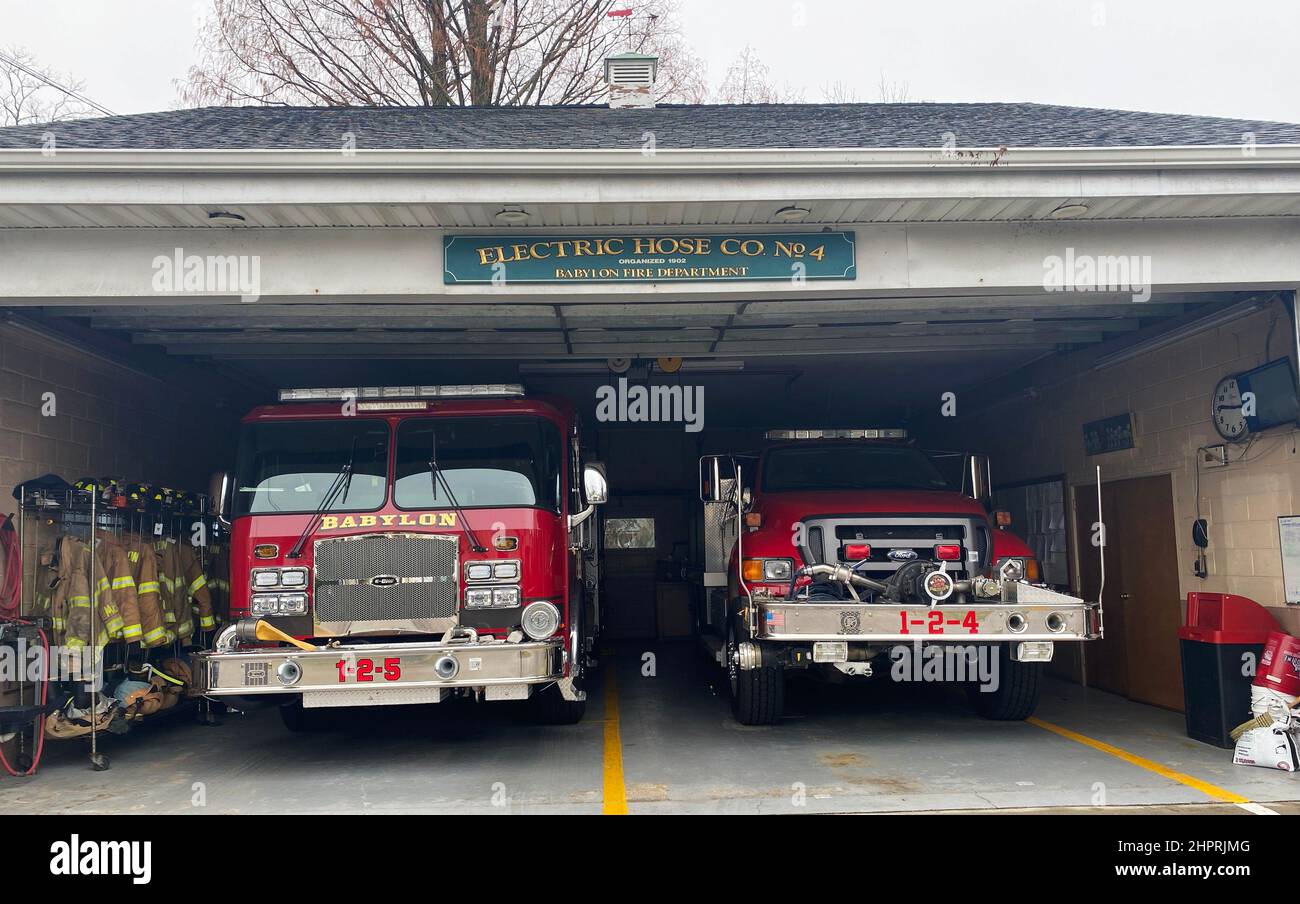 Babylon, New York, USA - 2 January 2022: Two fire trucks are backed into the Electric Hose Co number 4 fire station in Babylon New York. Stock Photo