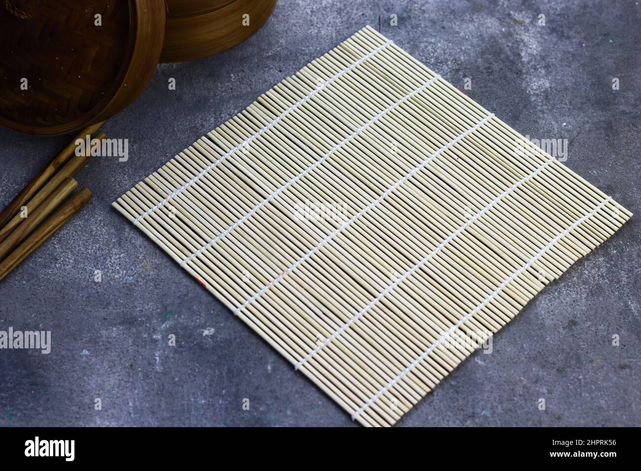 Sushi Roller mat on grey grainy background. Stock Photo